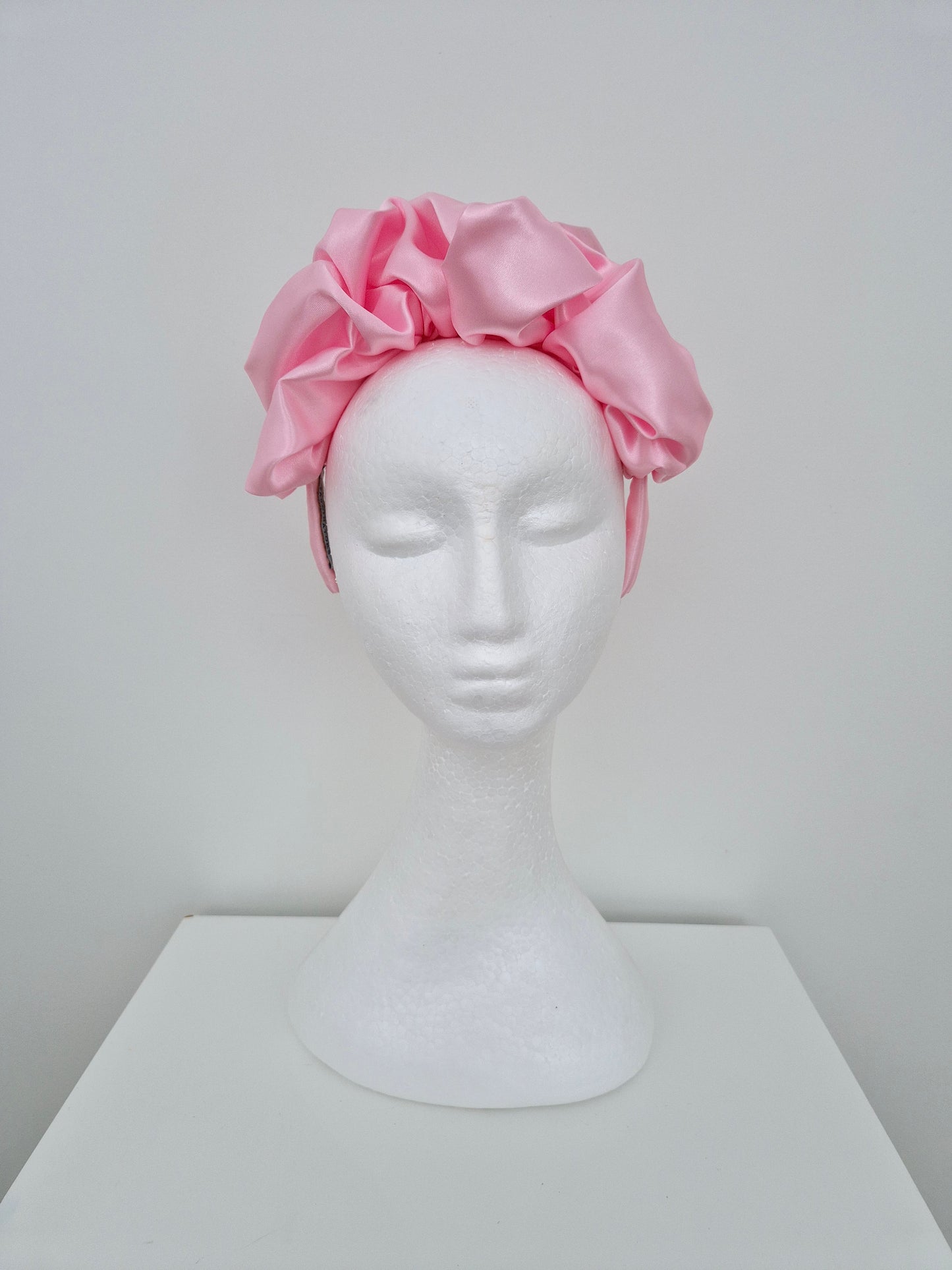 Miss Lauren. Womens satin scrunch headband fascinator in Pink icing