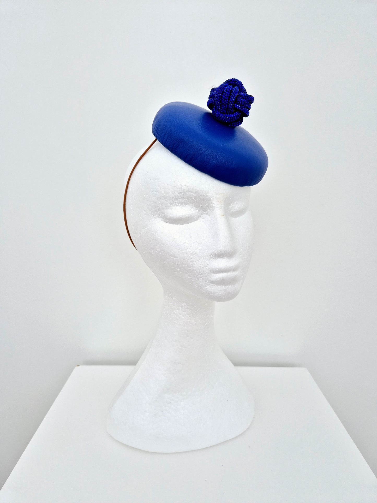 Miss Fia. Womens Royal Blue leather button fascinator with rhinestone knotted ball